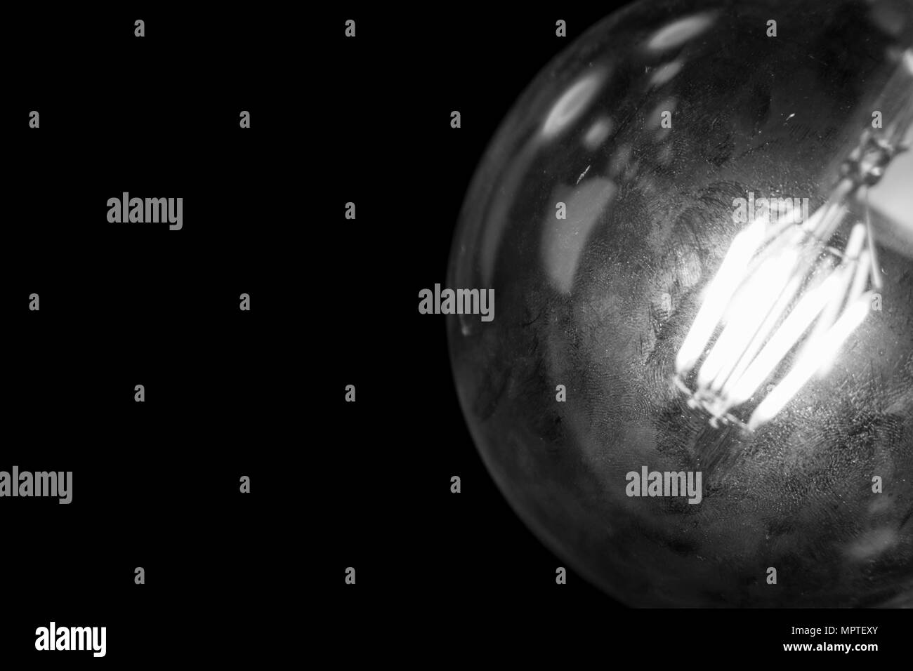 A vintage style glowing lightbulb, illuminate the dark room Stock Photo