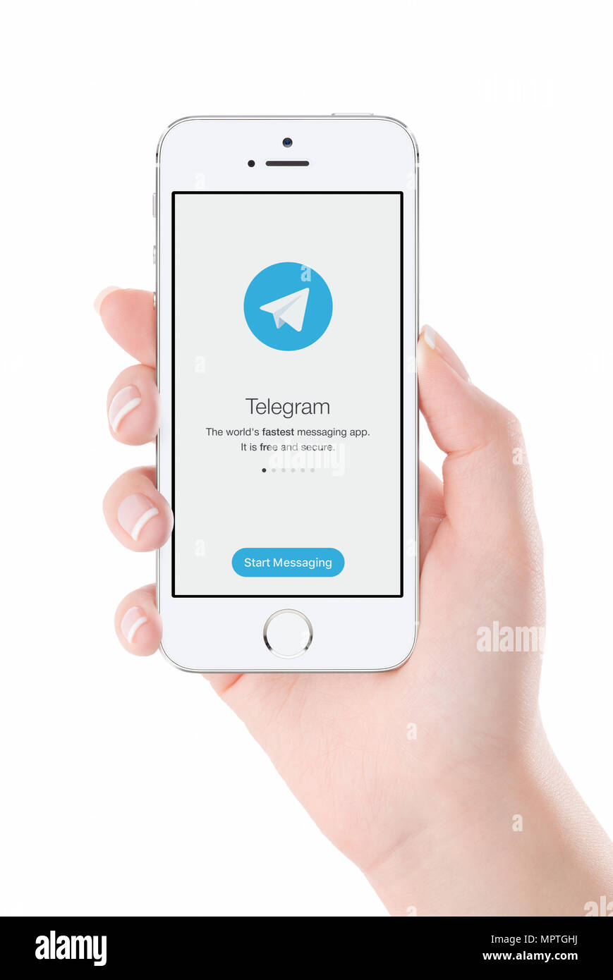 Telegram messenger launch screen on iPhone smartphone display in female hand. Stock Photo