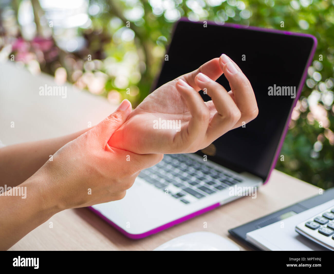 Closeup woman holding her wrist pain from using computer. Office