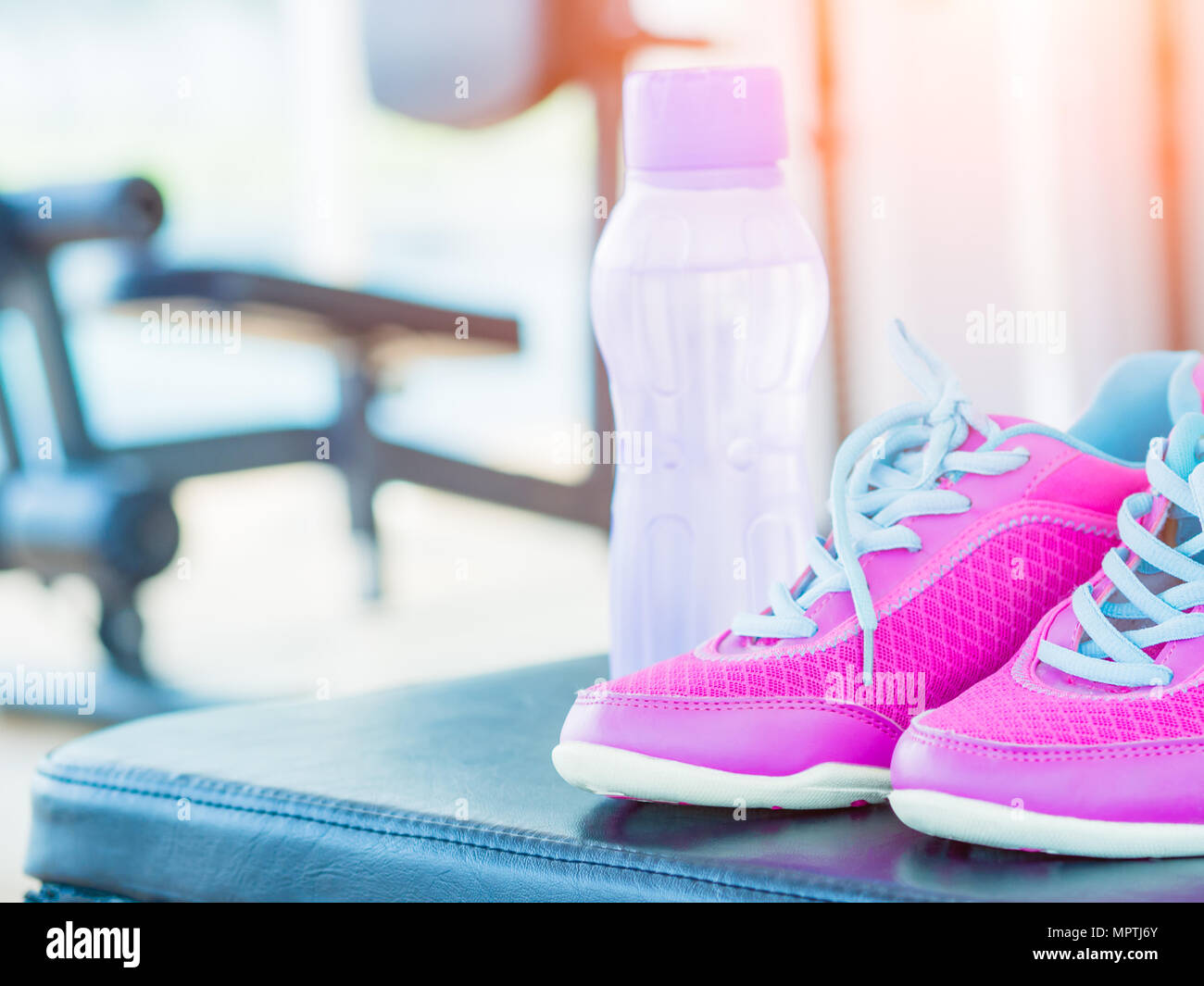 Pair of pink sport shoes and water bottle with fitness equipment  background. Accessories for running sport Stock Photo - Alamy