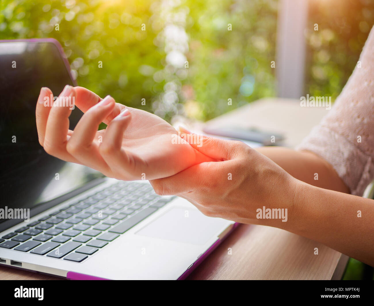 Closeup woman holding her painful hand from using computer. Office