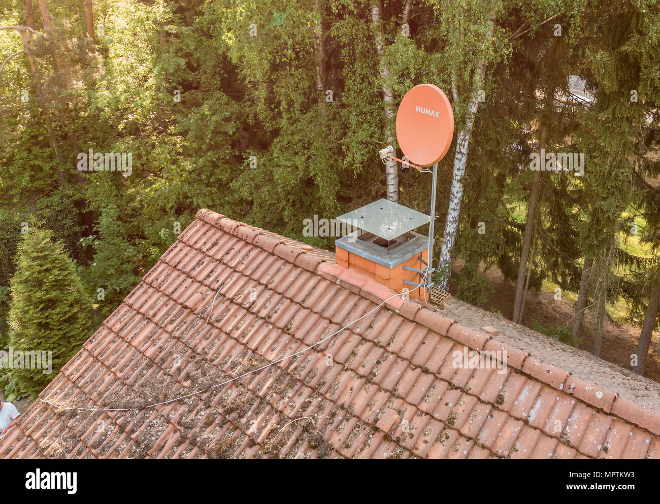 Overflight of the roof of a detached house to check the condition of the satellite antenna for the reception of television and Internet, aerial view m Stock Photo