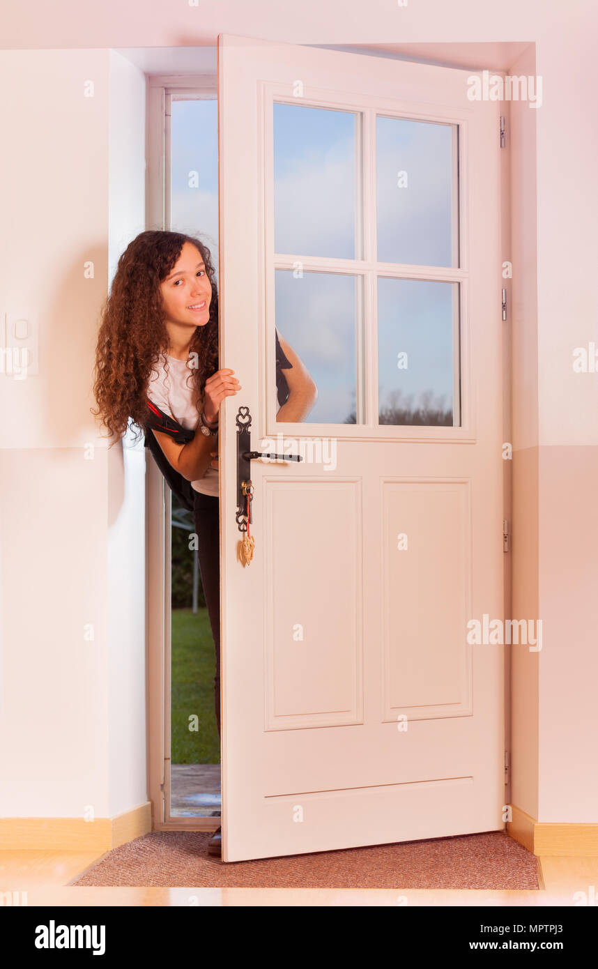 Cute Curly Teenage Girl Looking Through The Front Door Coming