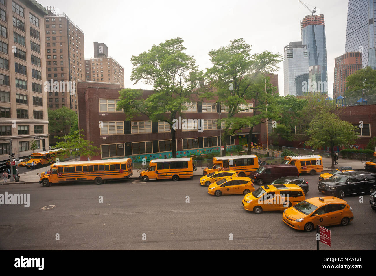 Traffic backs up as vehicles cannot legally pass a discharging school bus as the buses line up in front of PS 33 in Chelsea in New York on Friday, May 18, 2018. (Â© Richard B. Levine) Stock Photo
