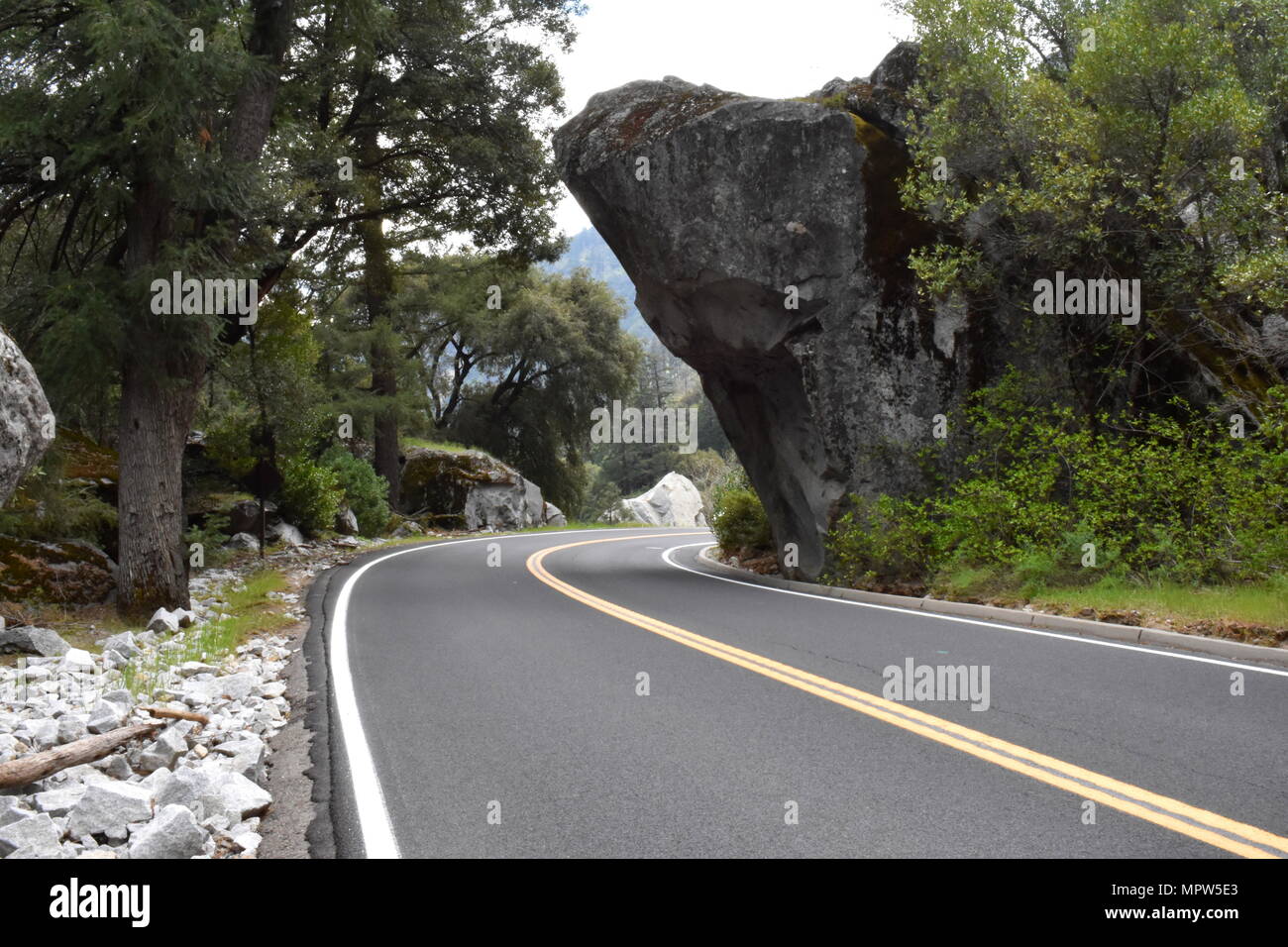 Road passing underneath a big boulder in Yosemite National Park, California Stock Photo