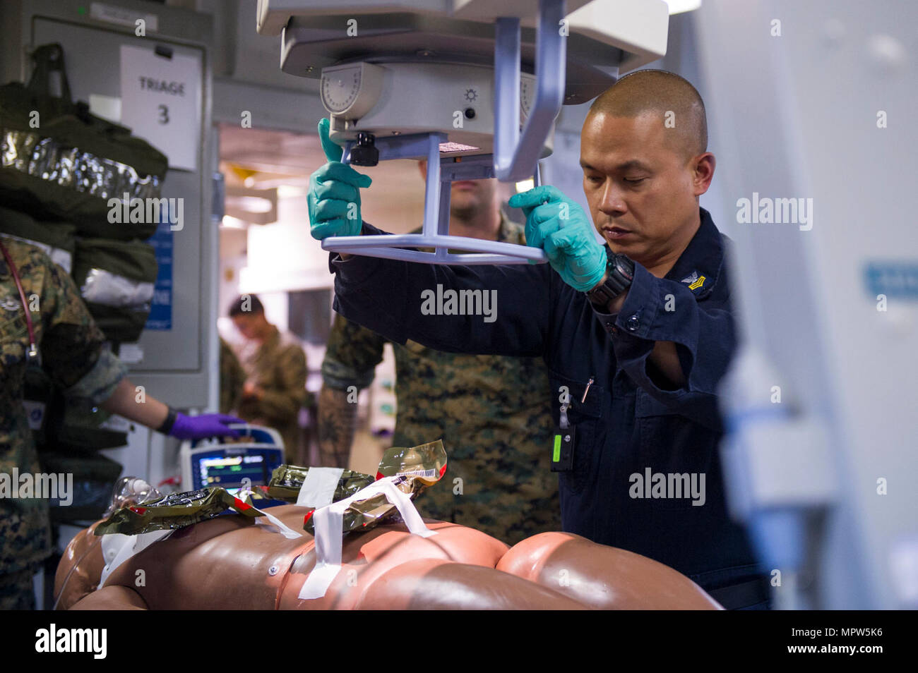 PACIFIC OCEAN (April 11, 2017) Hospital Corpsman 1st Class Loreto Cruz, a native of the Philippines, assigned to the medical team aboard the amphibious assault ship USS America (LHA 6) prepares a patient for an X-ray during a scheduled casualty evacuation drill. America is currently underway with more than 1,000 Sailors and 1,600 Marines conducting Amphibious Squadron/Marine Expeditionary Unit Integration operations in preparation for the ship's maiden deployment later this year. Stock Photo