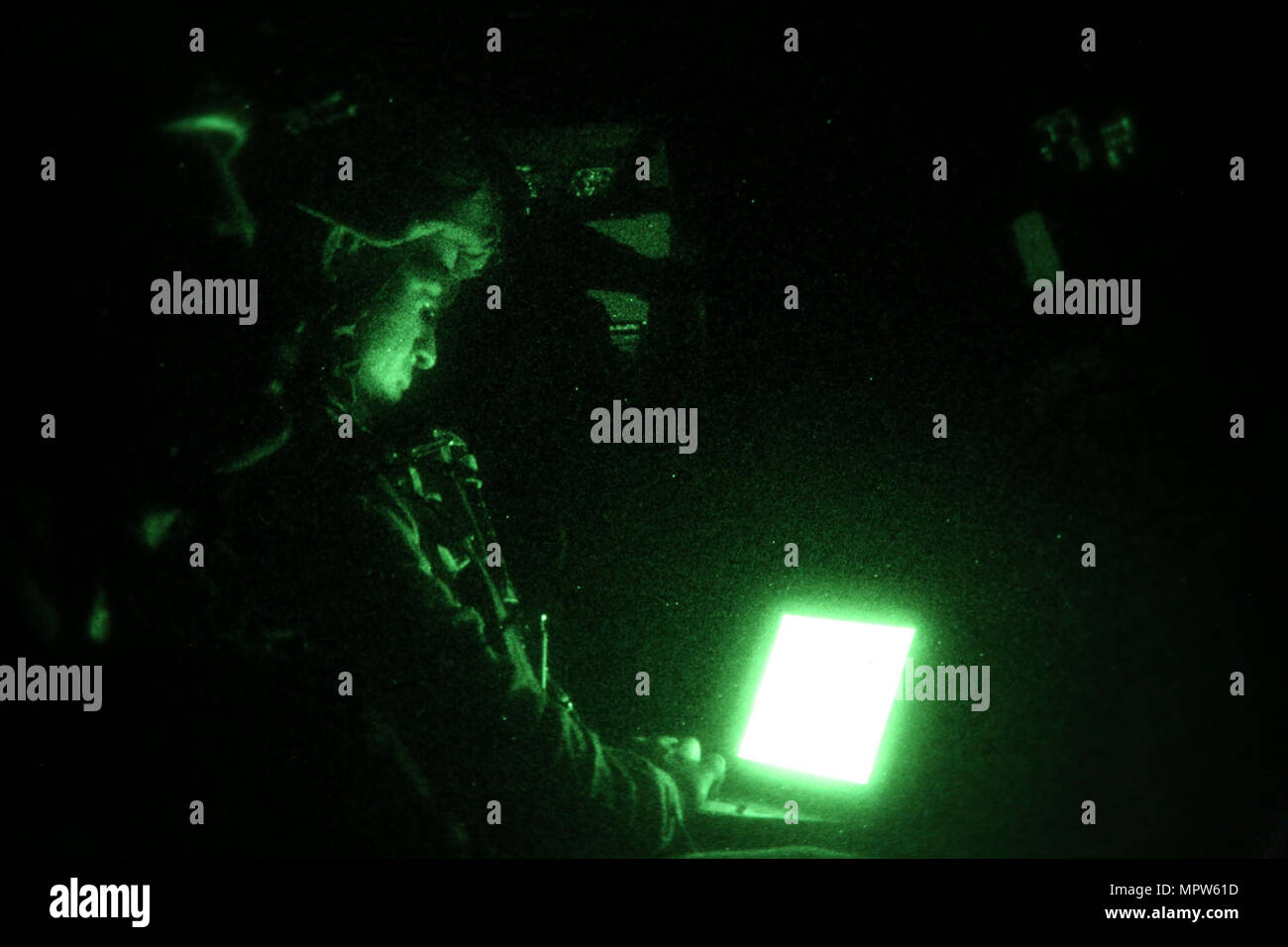 U.S. Marine Corps Cpl. Gabriel Alequin, a ground electronics telecommunications and information technology systems maintainer with 1st Battalion 7th Marines, Special Purpose Marine Air-Ground Task Force-Crisis Response-Central Command, sets up communications between an MV-22B Osprey tiltrotor aircraft and other aircraft in the area, during a night aerial refueling mission between Marine Medium Tiltrotor Squadron 165 and Marine Aerial Refueler Transport Squadron 352 while forward deployed in the Middle East, April 11, 2017. The training served as an opportunity for VMM-364 and VMGR-352 to incre Stock Photo