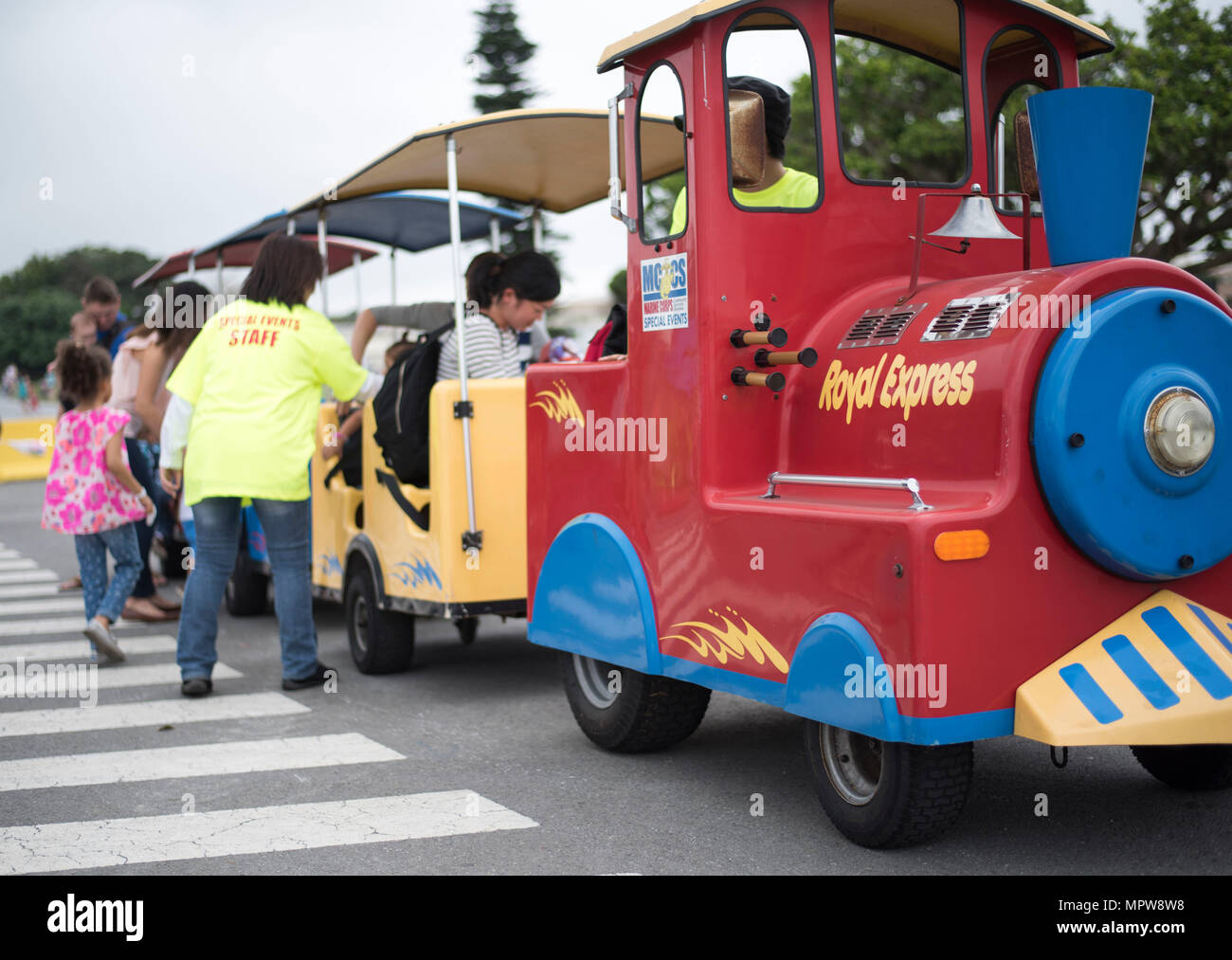 Children and families ride a train at the “Kiddie Land” section of the Eggsplosion event April 15, 2017, at Kadena Air Base, Japan. The 18th Force Support Squadron coordinated and worked together with Marine Corps Community Services on Okinawa to supply entertainment for service members, civilians, and their families during Eggsplosion. (U.S. Air Force photo by Senior Airman Omari Bernard/Released) Stock Photo