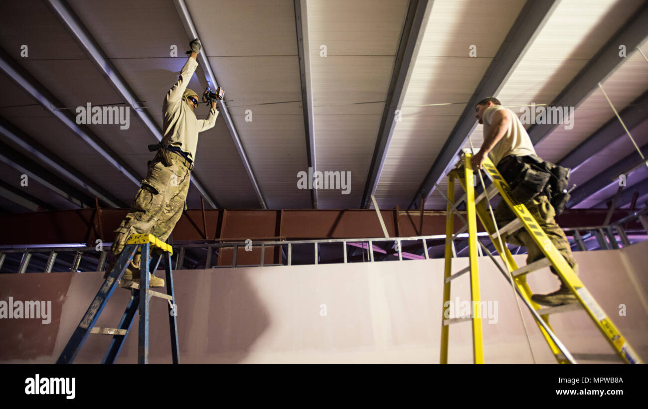 Staff Sgts. Theodore Sebsibe and Tyler MacDonald, 455th Expeditionary Prime BEEF Squadron electrical systems journeyman and craftsman respectively, drill holes in the ceiling of a newly-constructed airfield fire station at Bagram Airfield, Afghanistan March 24, 2017. The 577th EPBS augments the 455th Expeditionary Civil Engineer Squadron by providing military construction on long term, enduring projects. (U.S. Air Force photo by Staff Sgt. Katherine Spessa) Stock Photo