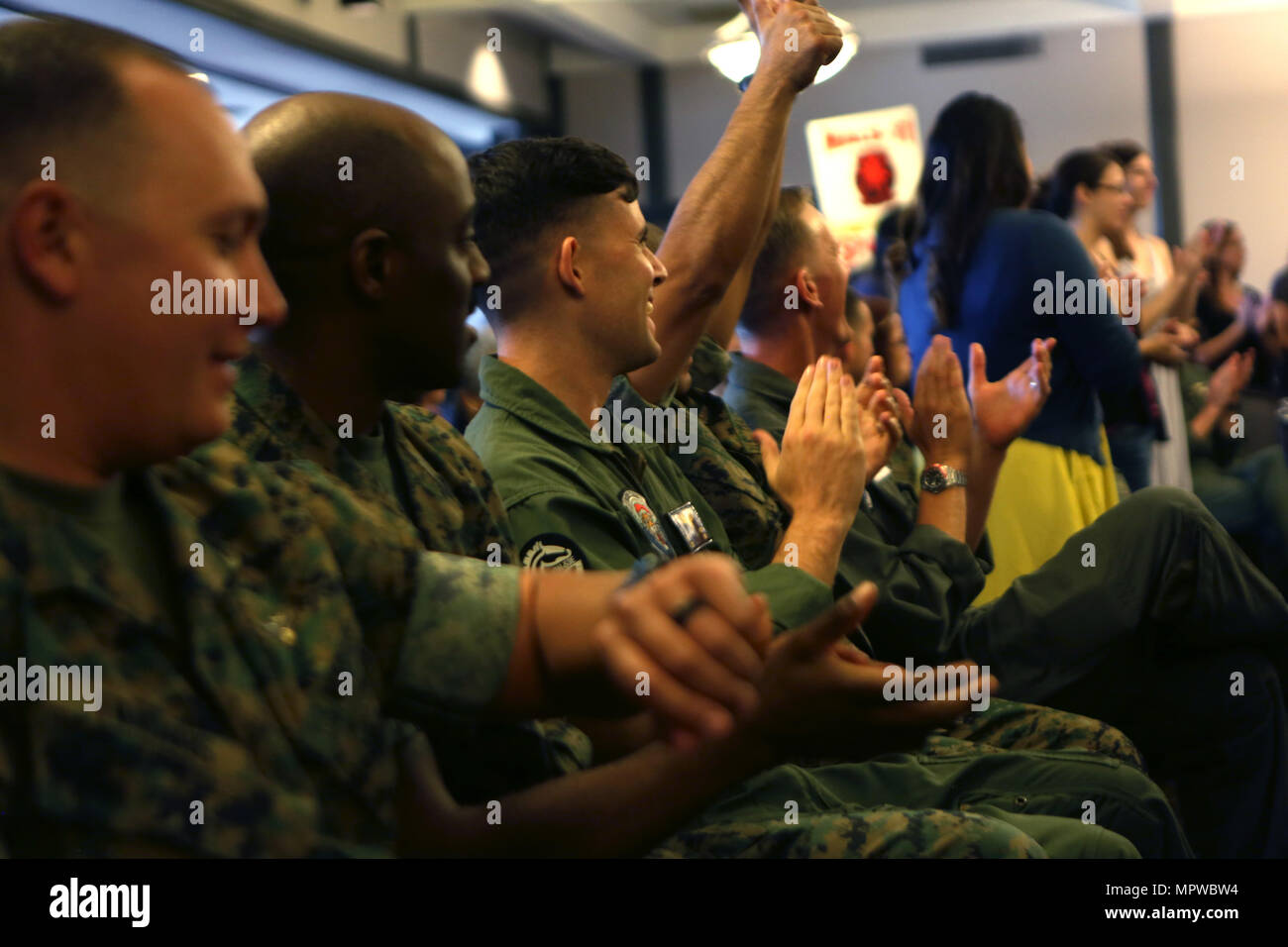 Service members from Marine Heavy Helicopter Squadron (HMH) 361, “Flying Tigers,” cheer for their unit volunteers during the Marine Corps Community Services volunteer appreciation ceremony at MCAS Miramar, April 19. This year’s volunteer service celebration recognized the selfless acts of over 100 volunteers from around MCAS Miramar and the surrounding community. (Marine Corps photo by Sgt. David Bickel/Released) Stock Photo