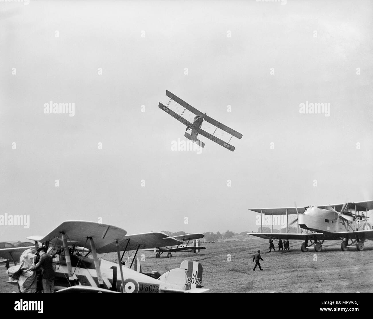 Avro 504 biplane flying very low over parked aircraft at the RAF Pageant, Hendon, London, 1927. Artist: Aerofilms. Stock Photo