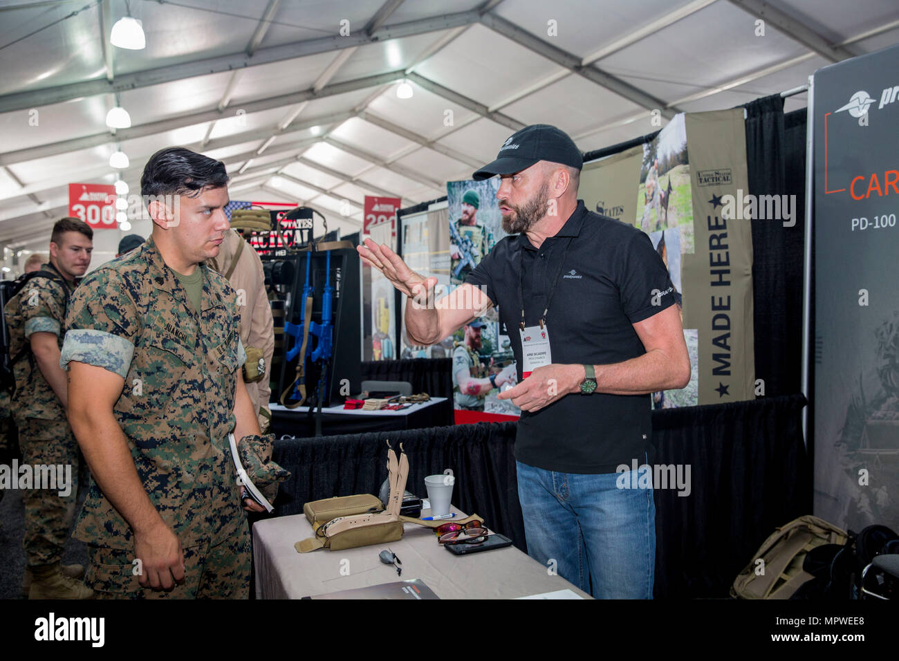 Arne Skjaerpe, right, field marketing director, Proxdynamics, speaks about the versatility of the company’s products to Marines during the Marine South Military Exposition, Goettege Field House, Camp Lejeune N.C., April 13, 2017. The Marine South Exposition is sponsored by the Marine Corps League and is a forum for defense contractors to display, inform, and promote the latest in defense equipment and technology. (U.S. Marine Corps photo by Lance Cpl. Ashley D. Gomez) Stock Photo