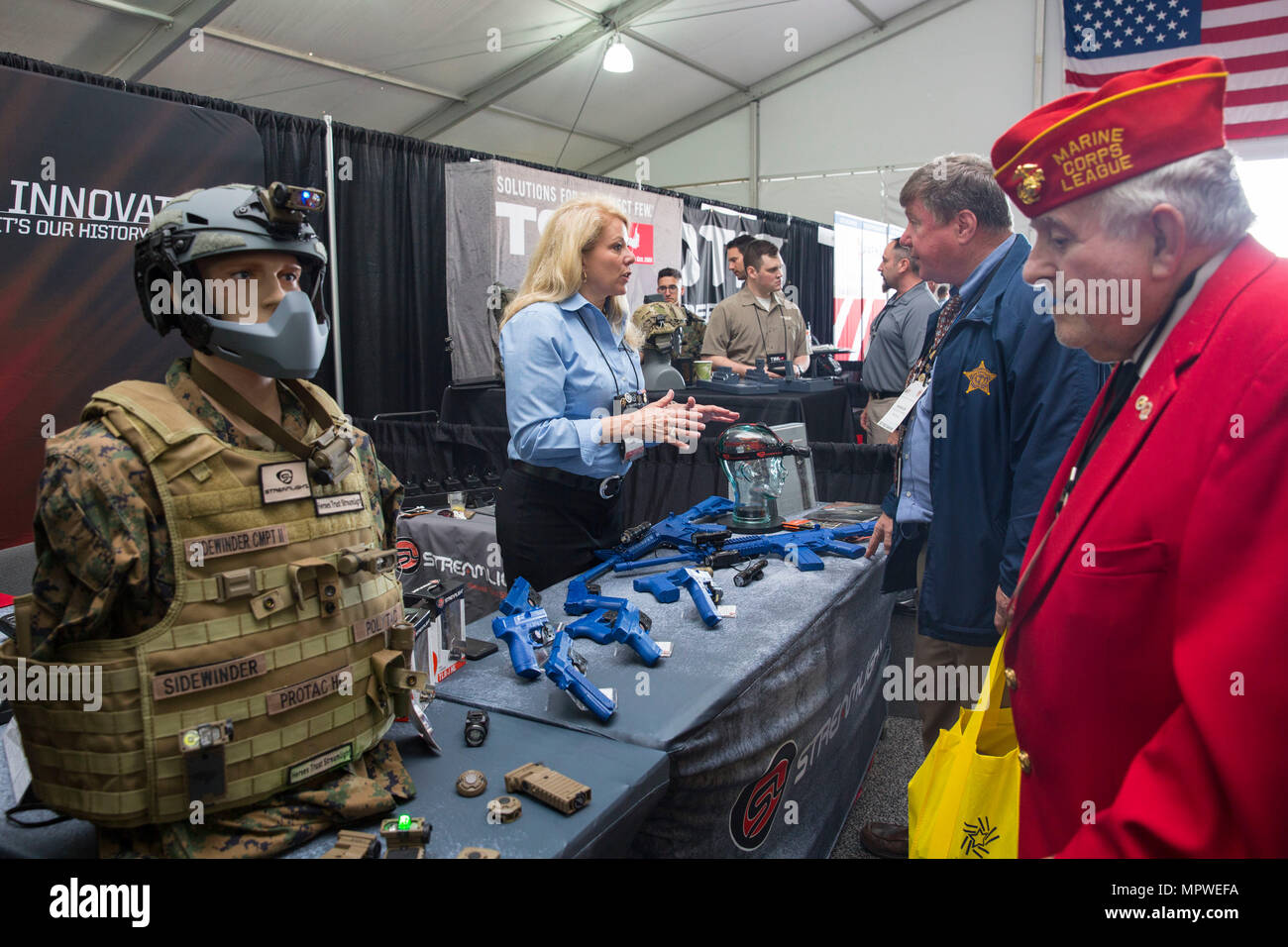 Sherry Lyons, regional military and federal division sales manager for Streamlight Inc., speaks with spectators about the display of weapons during the Marine South Military Exposition, Goettege Field House, Camp Lejeune N.C., April 13, 2017. The Marine South Exposition is sponsored by the Marine Corps League and is a forum for defense contractors to display, inform, and promote the latest in defense equipment and technology. (U.S. Marine Corps photo by Lance Cpl. Ashley D. Gomez) Stock Photo