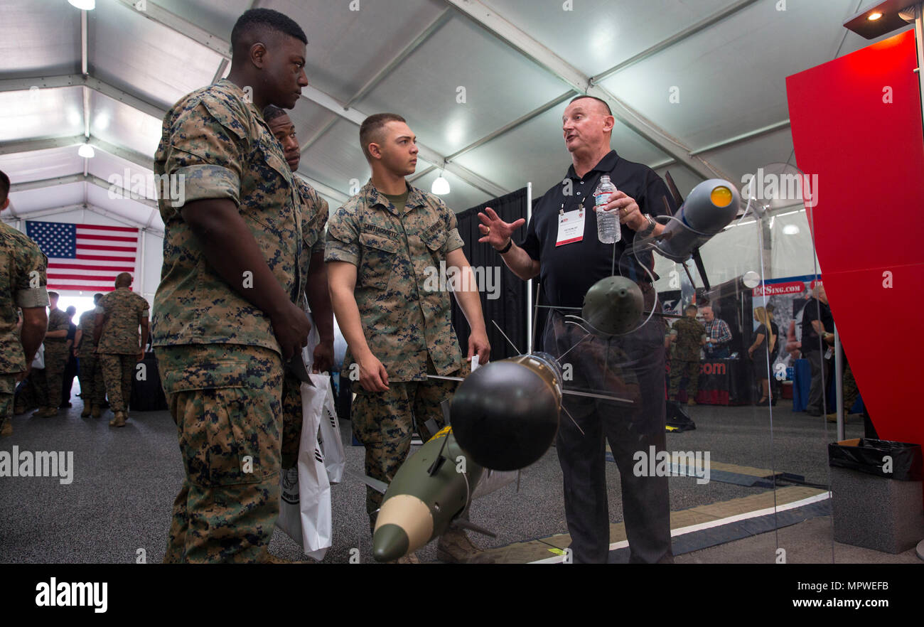 Ed Dunlap, business director for missile and warfare systems, Raytheon, shows and explains different missiles to Marines at the Marine South Military Exposition, Goettege Field House, Camp Lejeune N.C., April 13, 2017. The Marine South Exposition is sponsored by the Marine Corps League and is a forum for defense contractors to display, inform, and promote the latest in defense equipment and technology. (U.S. Marine Corps photo by Lance Cpl. Ashley D. Gomez) Stock Photo
