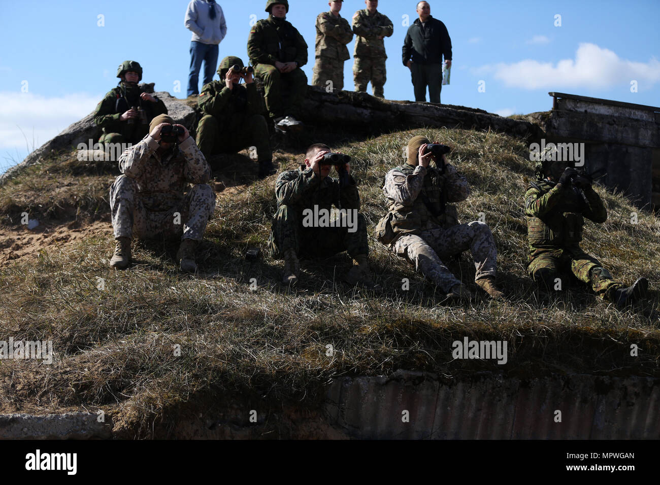 A U.S. Marine with Black Sea Rotational Force 17.1 and NATO Allies observe mortar fire during a joint fire observer exercise aboard Adazi Military Base, Latvia, April 20, 2017. The event was a part of Exercise Summer Shield, a multinational training evolution designed to bring NATO Allies together through combined training efforts. (U.S. Marine Corps photo by Cpl. Sean J. Berry) Stock Photo