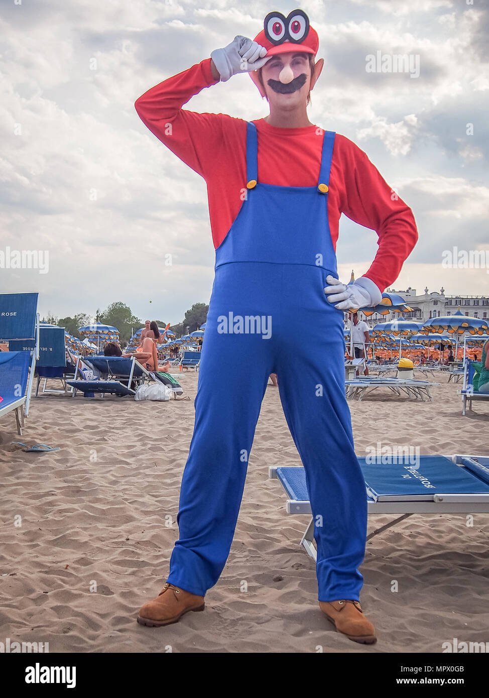 RIMINI, ITALY-JULY 22, 2017: Young cosplayer man in the Mario costume posing on the beach Stock Photo