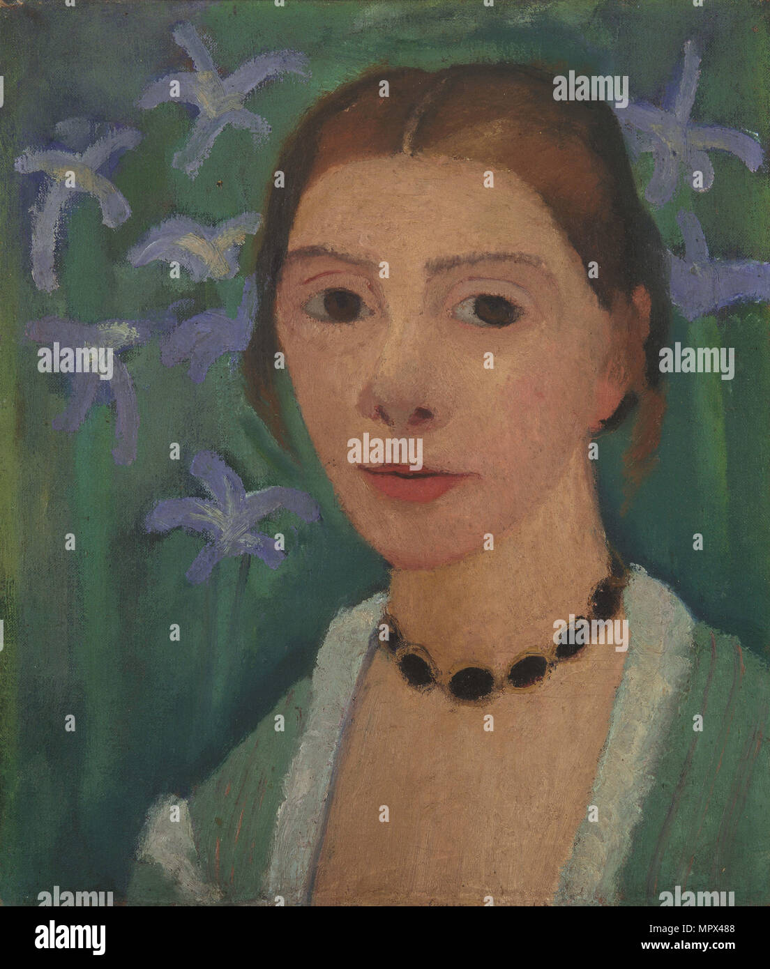 Self portrait in front of green background with blue irises, c. 1905. Stock Photo