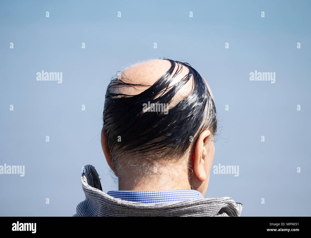 Rear view of balding eldery man with comb over Stock Photo