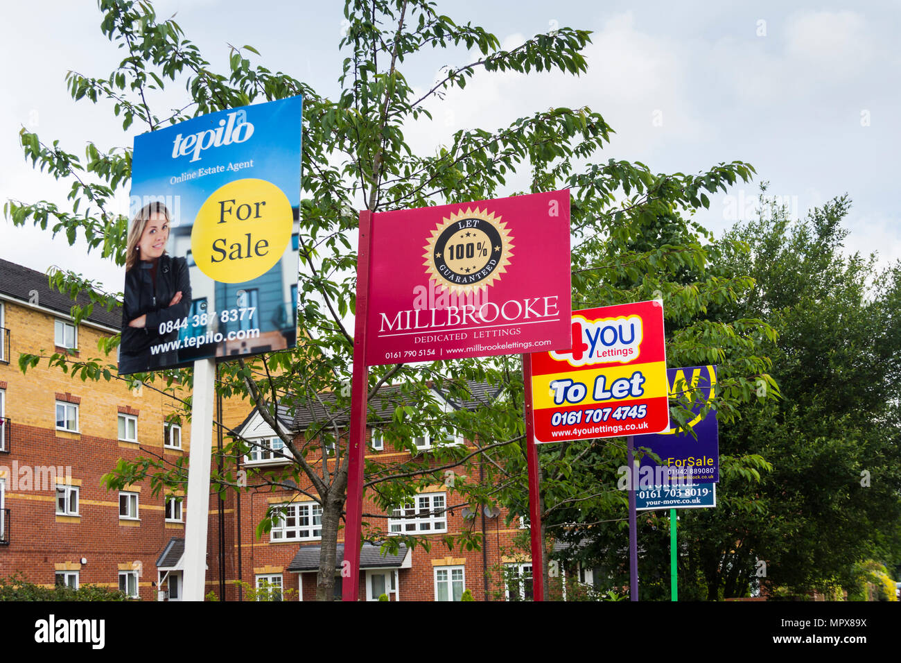 Property for sale and to let signs from a variety of estate agents outside a block of modern apartments, Hatherton Court, Worsely Road North, Walkden, Stock Photo