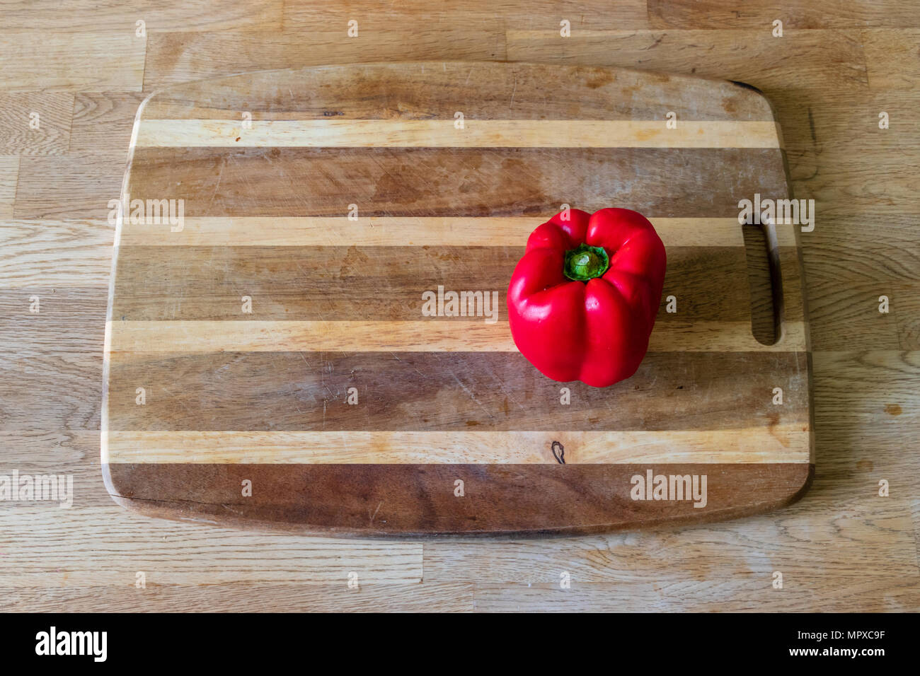 A red pepper on a chopping board Stock Photo