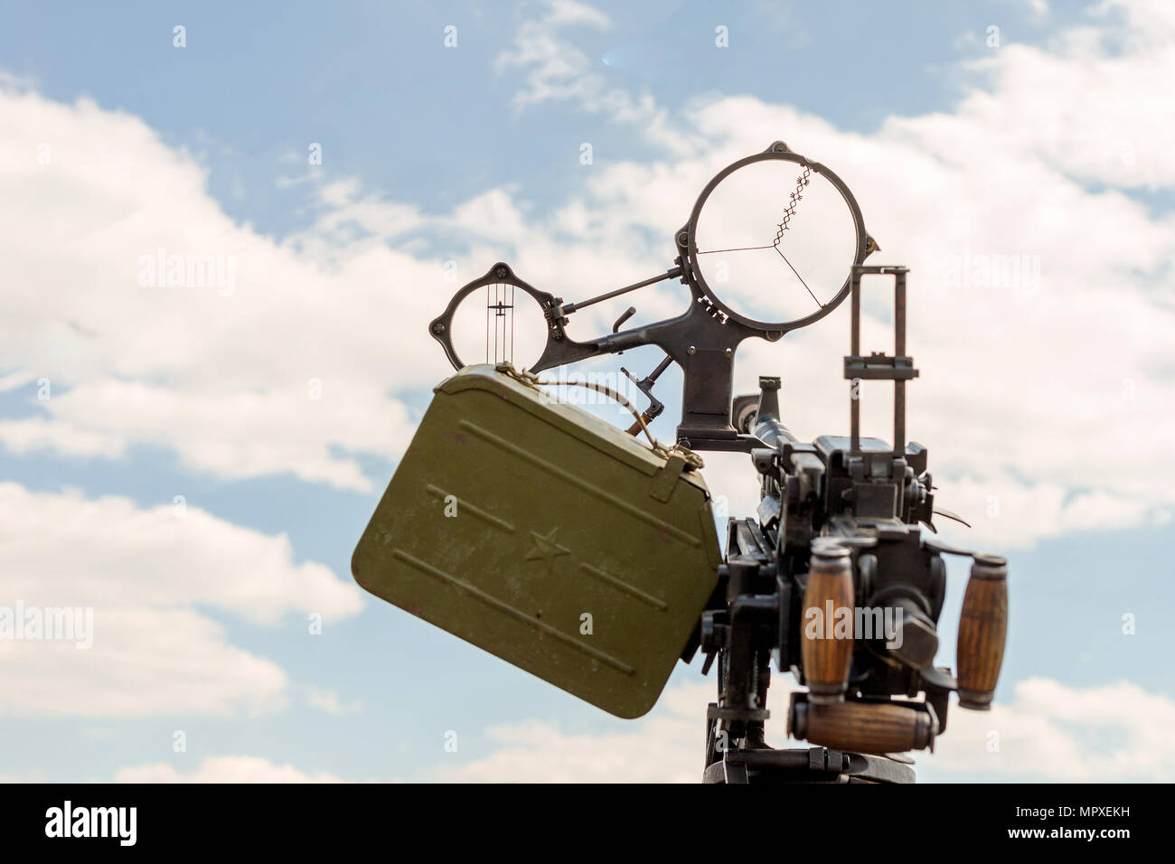 Old ww2 time anti-aircraft machine gun. Close-up front view with cannon aim against clear blue sky. Stock Photo