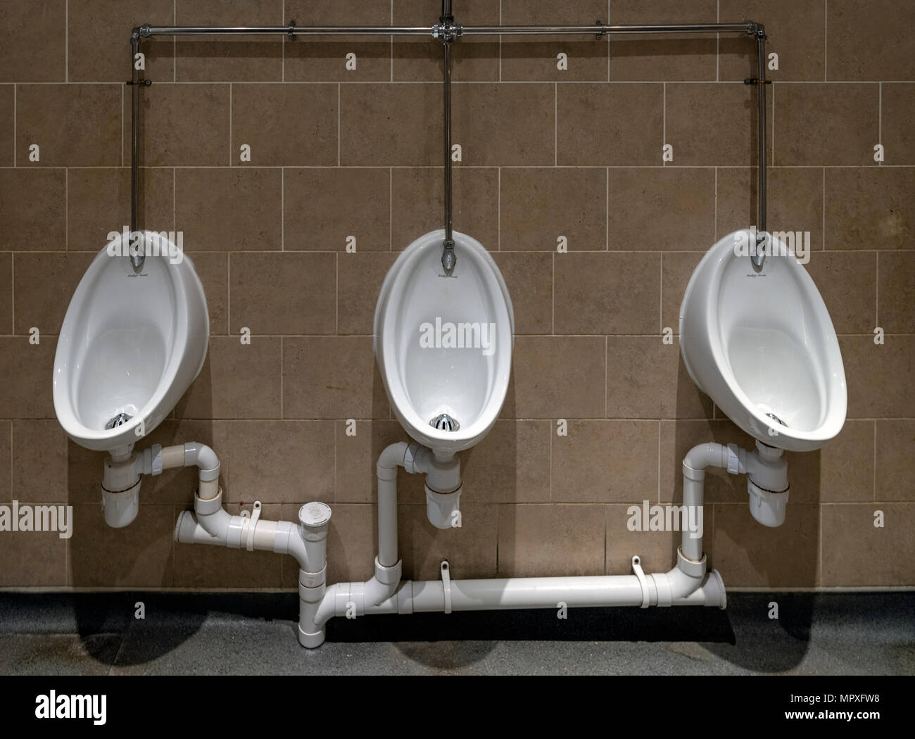 Men's urinals inline in a gent's toilet Stock Photo