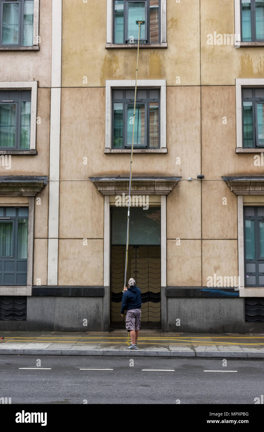 a window cleaner working cleaning windows on a multistorey building