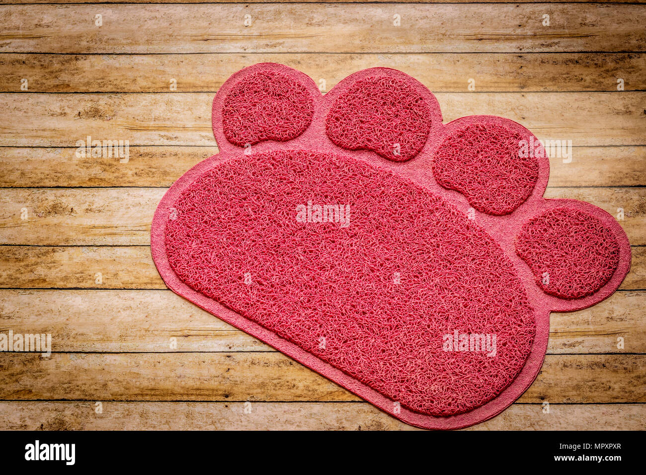 Pink cat litter trapping mat on wood background Stock Photo