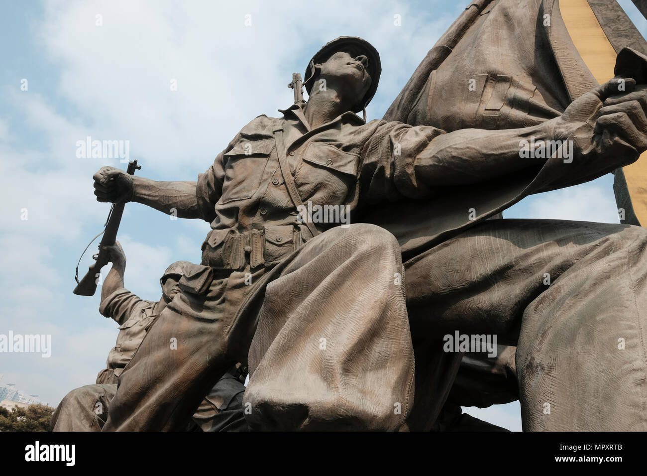 Monument depicting scene of the Korean war displayed at the entrance to the War Memorial of Korea museum located in Yongsan-gu district on the former site of the army headquarters to exhibit and memorialize the military history of Korea in the city of Seoul capital of South Korea Stock Photo