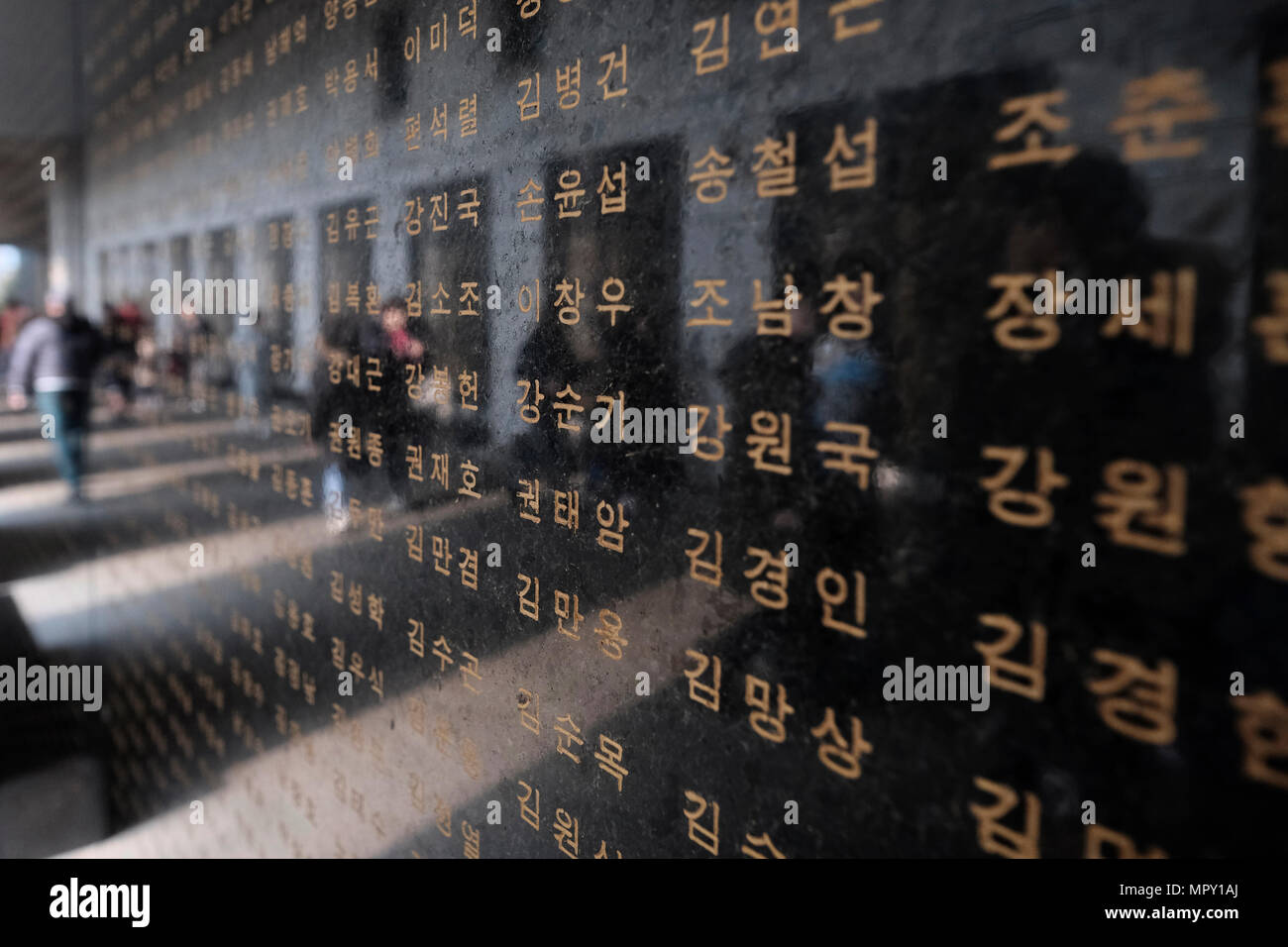 Korean visitors are reflected in a marble panel with names of soldiers killed during the Korean War at the remembrance hall at the War Memorial of Korea museum located in Yongsan-gu district in the city of Seoul capital of South Korea Stock Photo