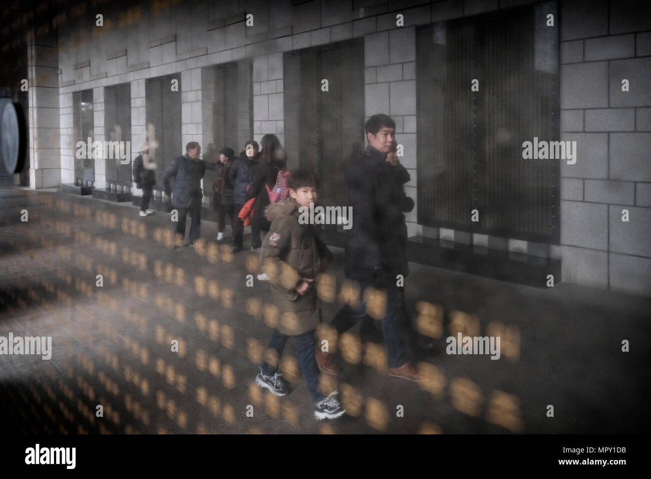 Korean visitors are reflected in a marble panel with names of soldiers killed during the Korean War at the remembrance hall at the War Memorial of Korea museum located in Yongsan-gu district in the city of Seoul capital of South Korea Stock Photo