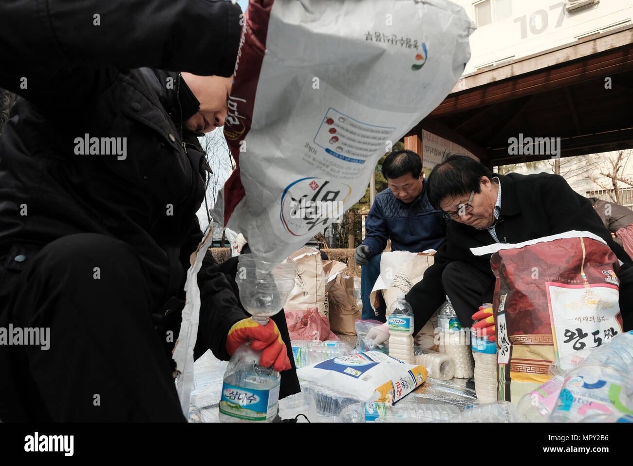 Members of the North Korean Refugees Human Rights Association of Korea (NKR) filling rice in plastic bottles with a written message which reads 'God loves you' to be send to North Korea from South Korea's Ganghwa Island in hope that they would be picked up by North Koreans and help change the attitude that North Koreans have towards people in the South. Stock Photo
