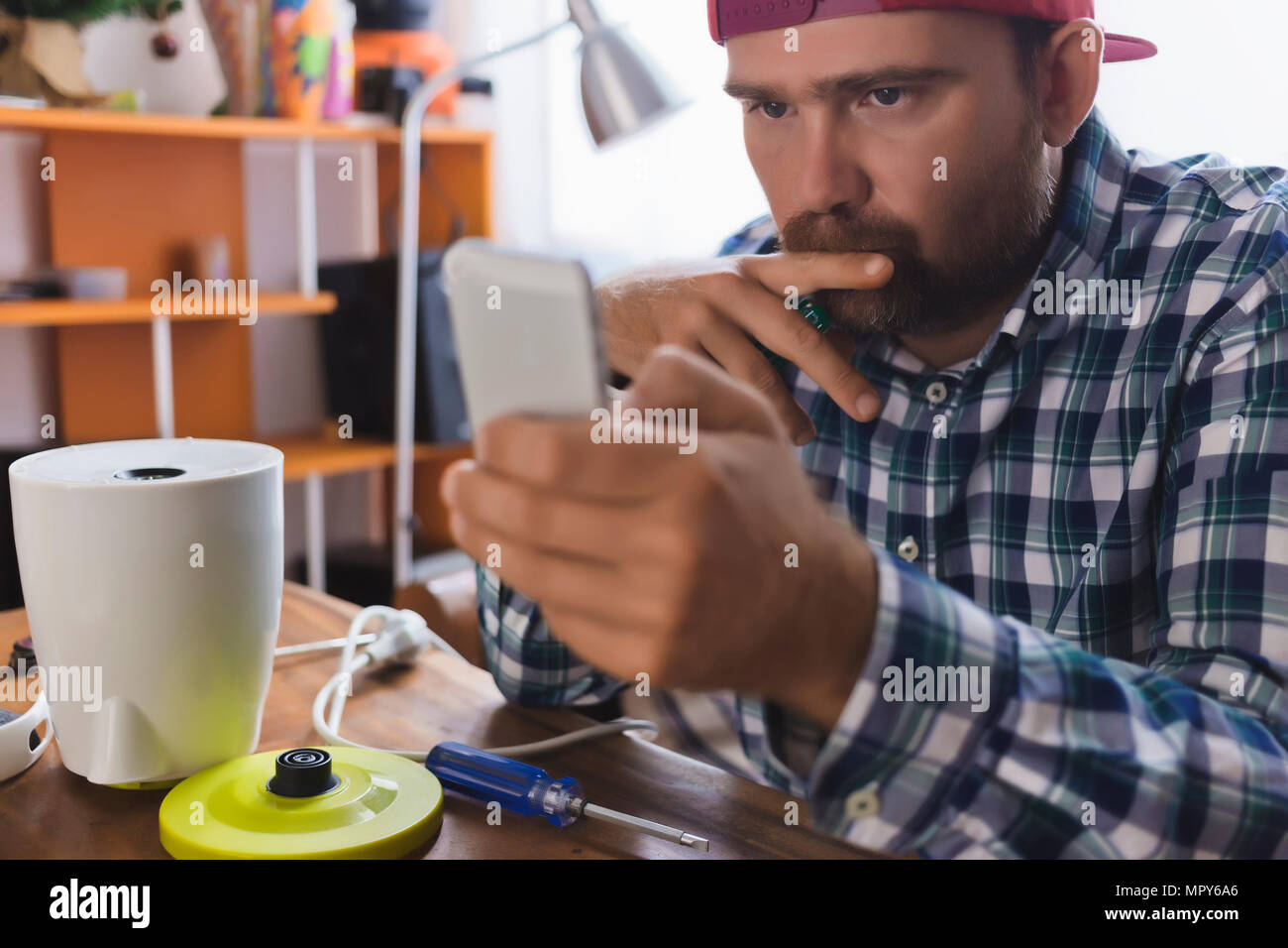 Serious man using smart phone at home Stock Photo