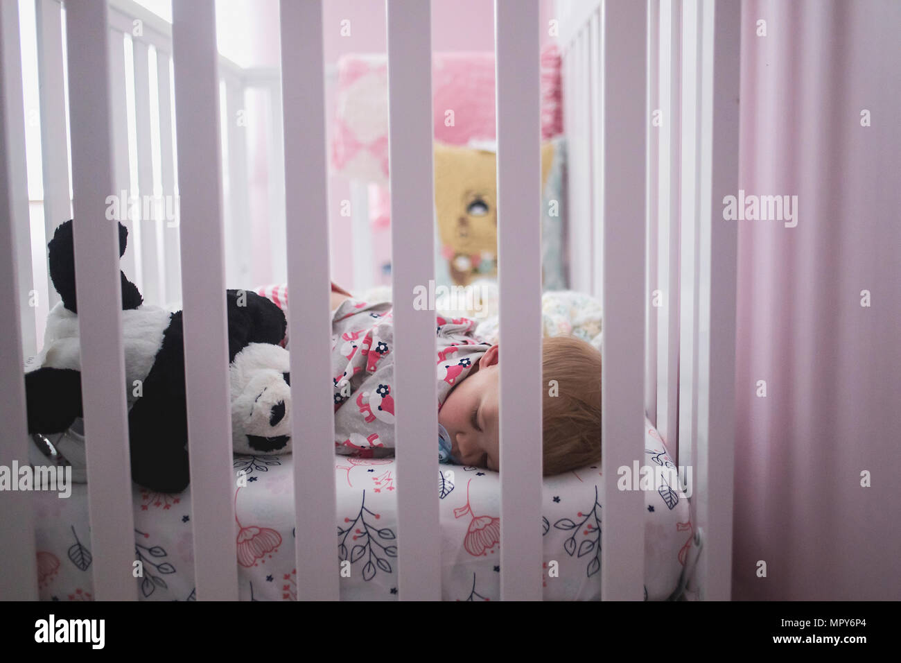 Baby girl sleeping in crib hi-res stock photography and images - Alamy