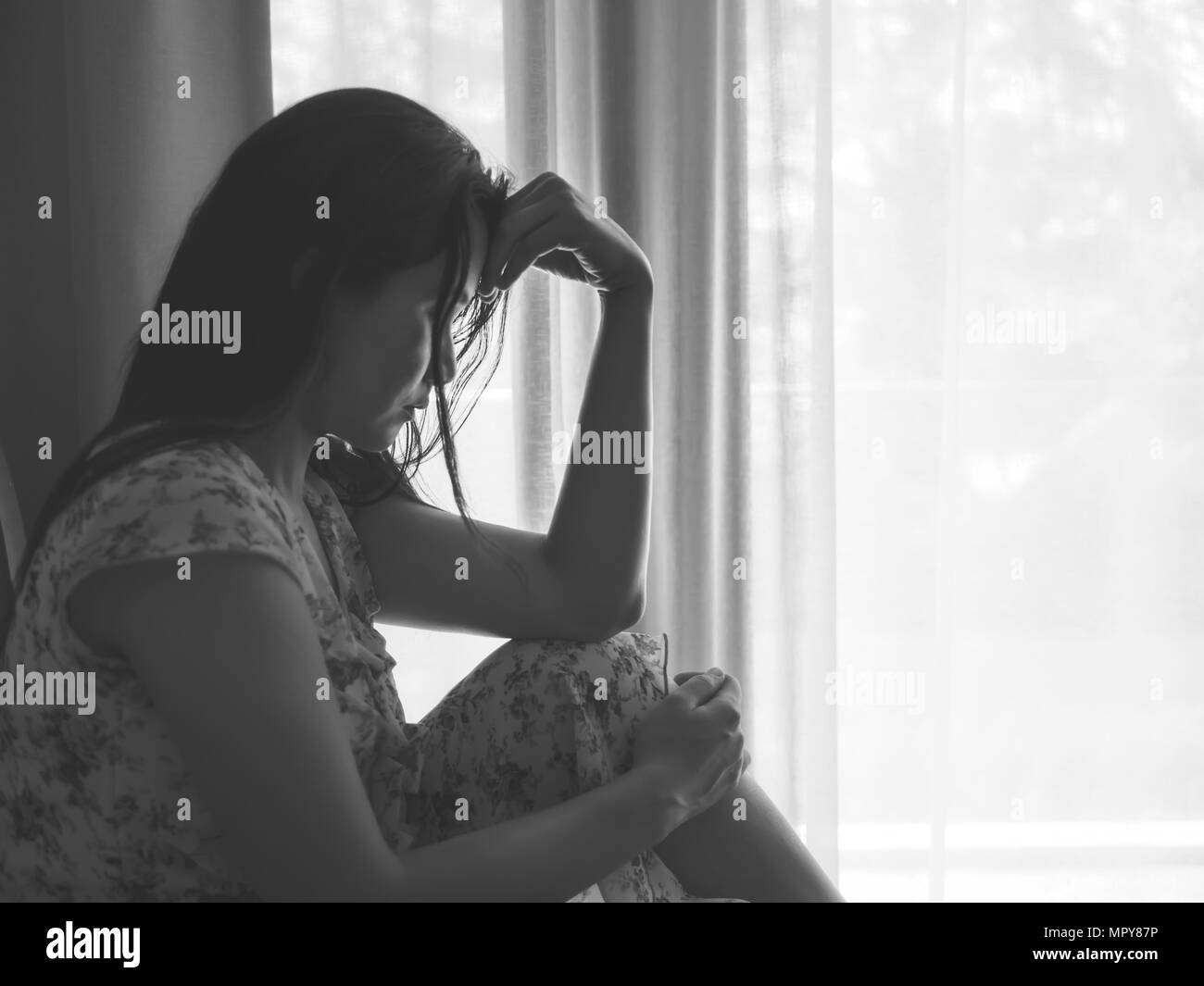 Closeup depressed woman crying while sitting alone on the floor. Sad woman concept. Stock Photo