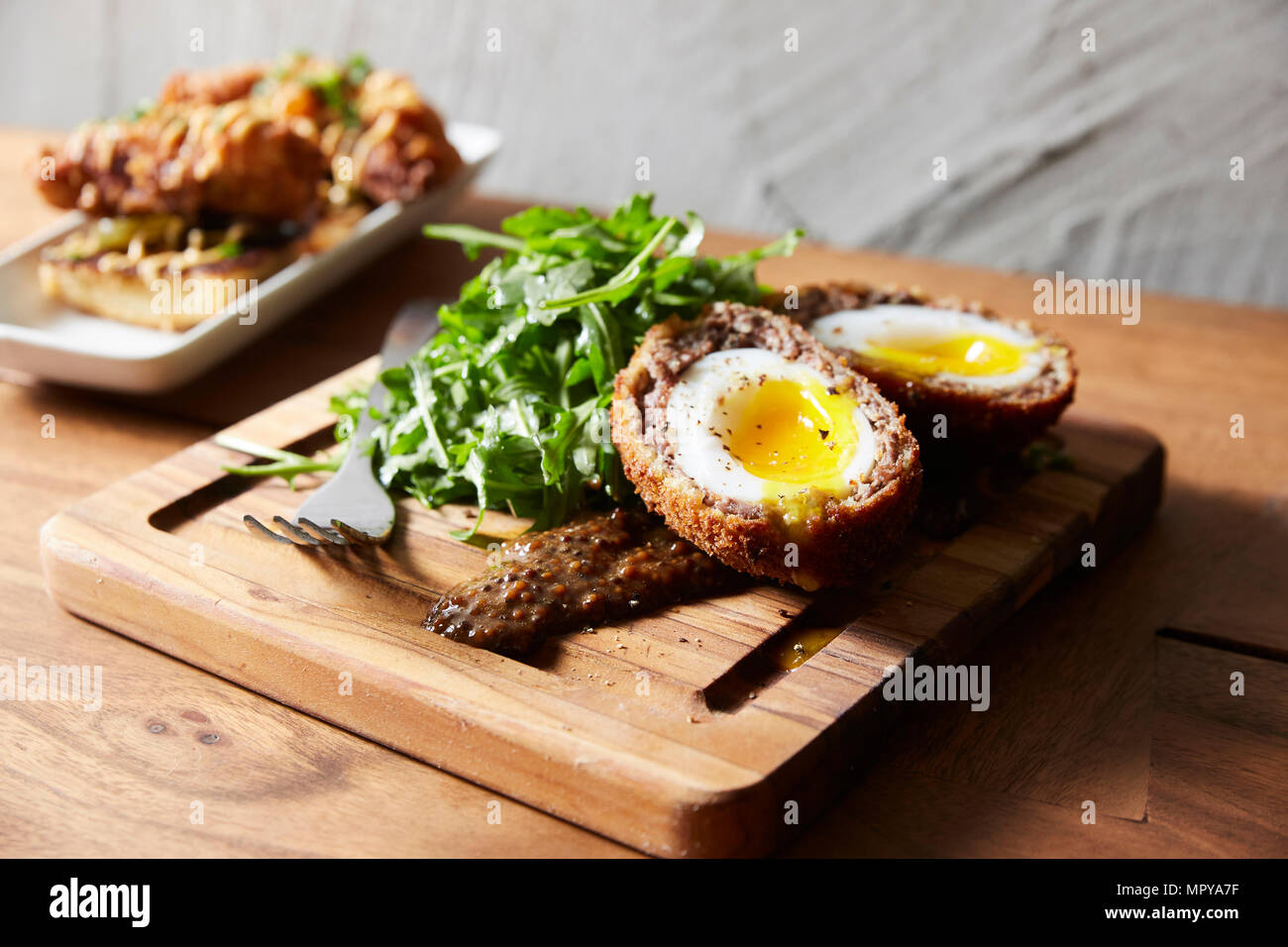 High angle view of scotch eggs with arugula served on serving board Stock Photo