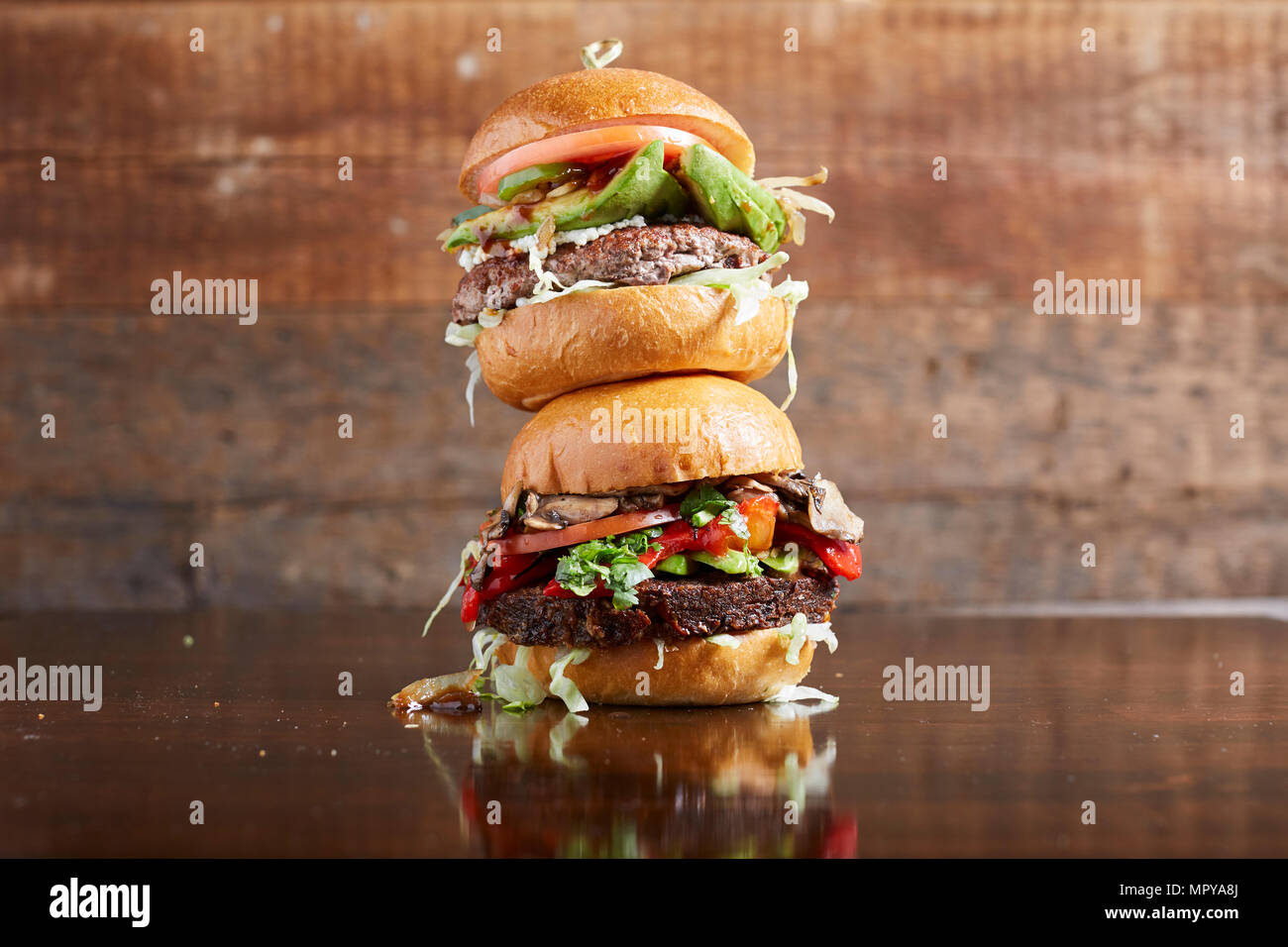 Close-up of cheeseburgers on wooden table Stock Photo