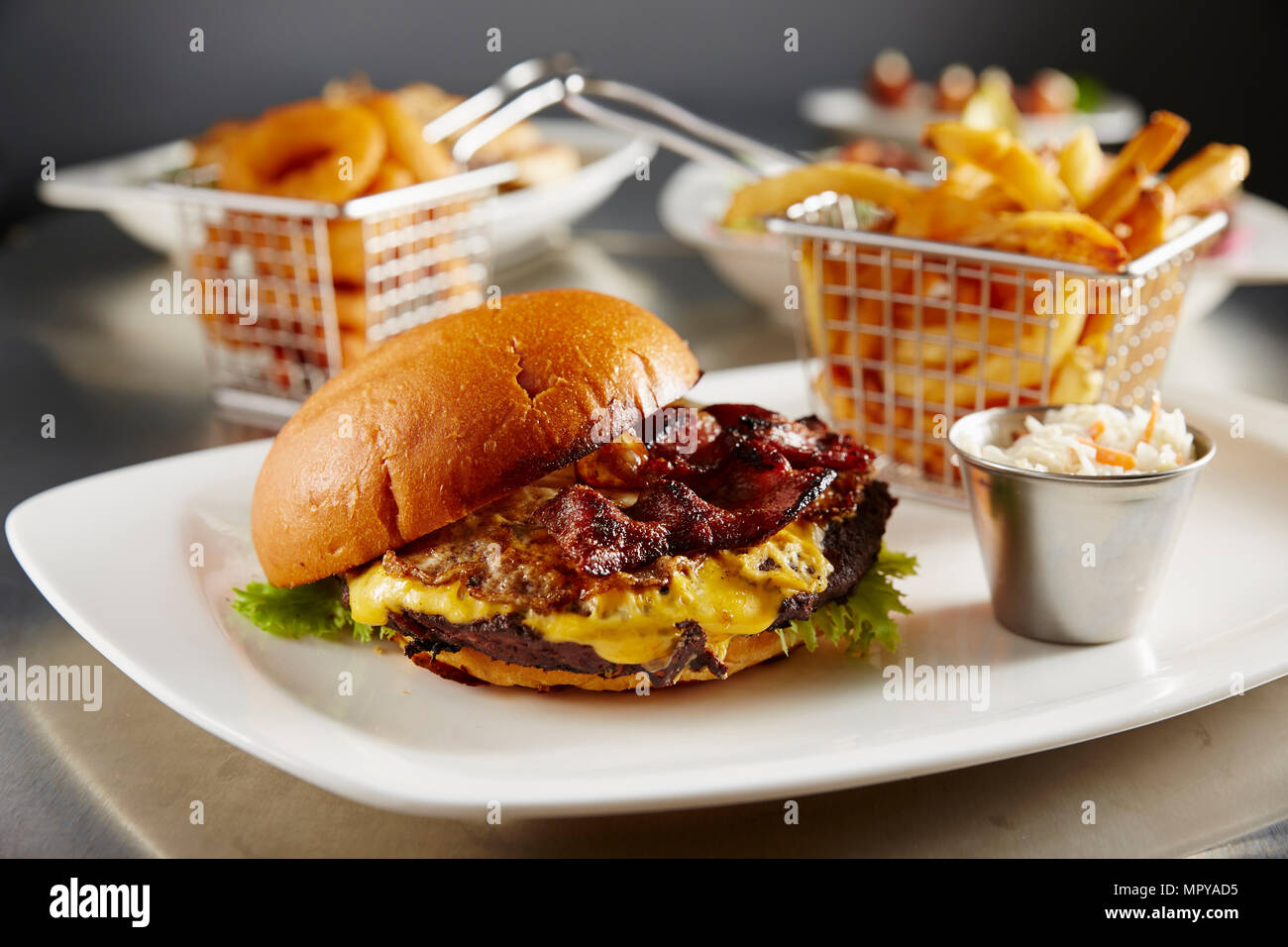 Closeup of cheeseburger with French fries served in plate on table