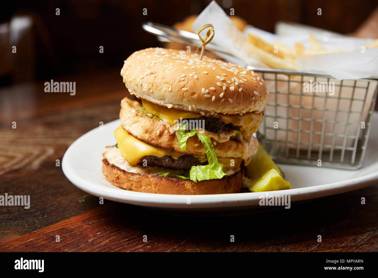 Close-up of cheeseburger served in plate on table Stock Photo
