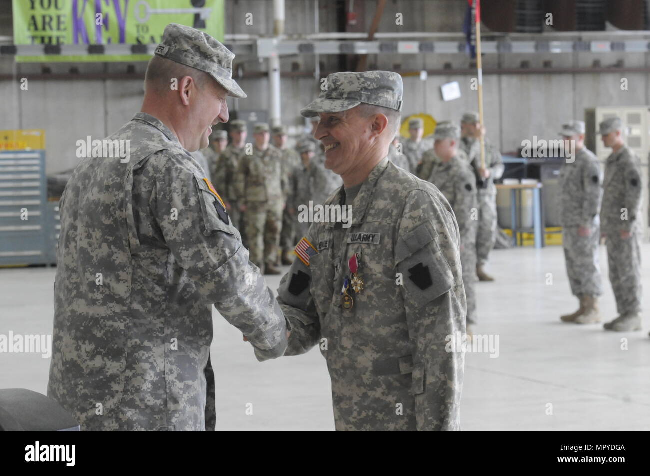 U.S. Army Col. Dennis Sorensen, right, outgoing commander of the 28th Combat Aviation Brigade, shakes hands with Brig. Gen. Andrew Schafer, commander of the 28th Infantry Division during a change of command ceremony at Muir Army Airfield, April 23, 2017. Sorensen was recognized for his service and moves on after 29 years in the 28th CAB. Stock Photo
