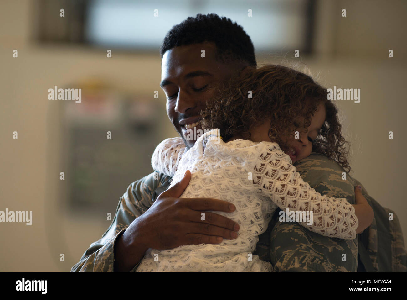 Air Force Staff Sgt. Joshuah Curry, a quality assurance technican with the 3rd Maintenance Group hugs his three-year-old daughter Autumn at Hangar 25 on Joint Base Elmendorf-Richardson, Alaska April 21 upon returning from a 7-month deployment. For many families, this was their first time being separated from their loved ones for an extended period of time. (U.S. Air Force photo by Senior Airman Kyle Johnson) Stock Photo