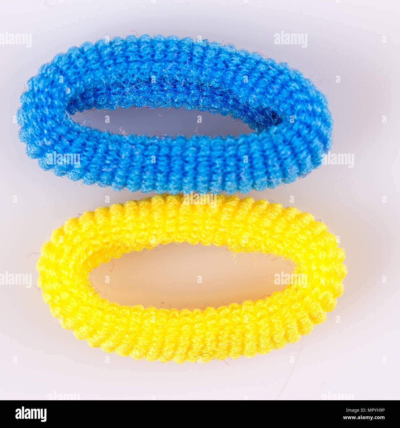Yellow and blue soft hair bands on a white background Stock Photo