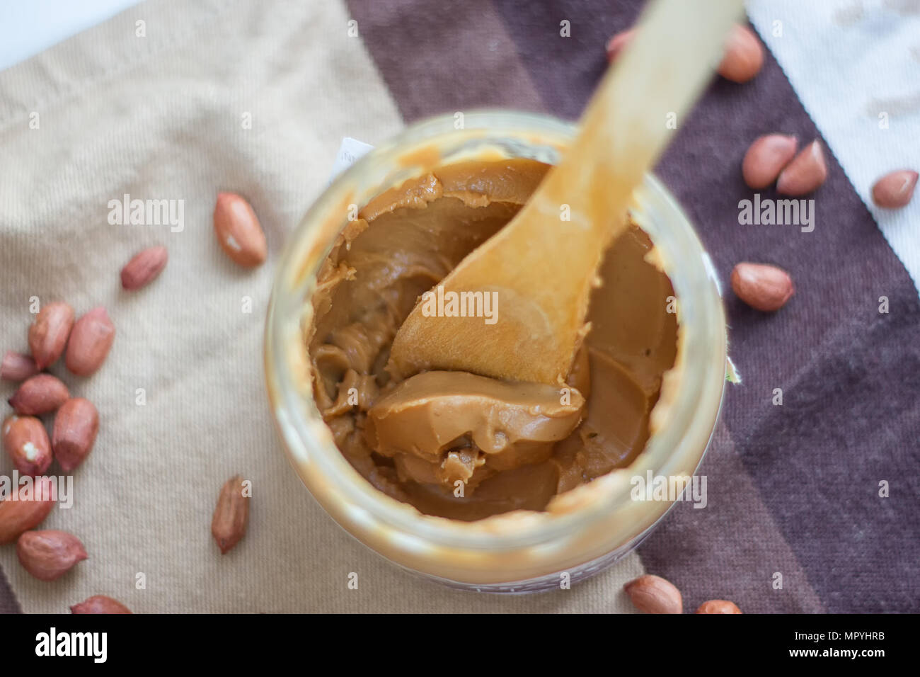 an open jar of peanut butter with spoon Stock Photo Alamy