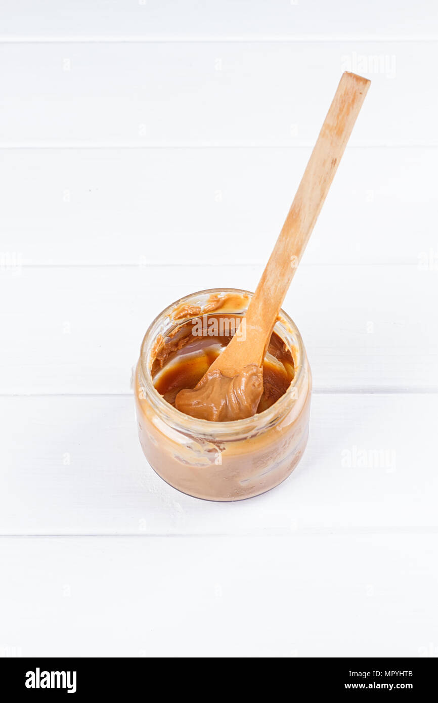 an open jar of peanut butter with spoon Stock Photo Alamy