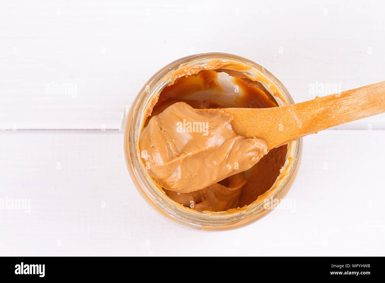 an open jar of peanut butter with spoon Stock Photo Alamy