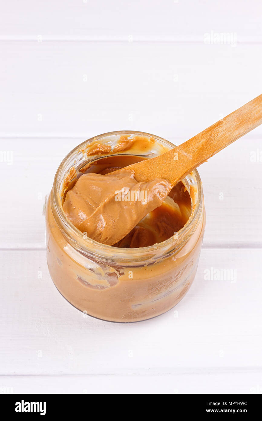 an open jar of peanut butter with spoon Stock Photo Alamy