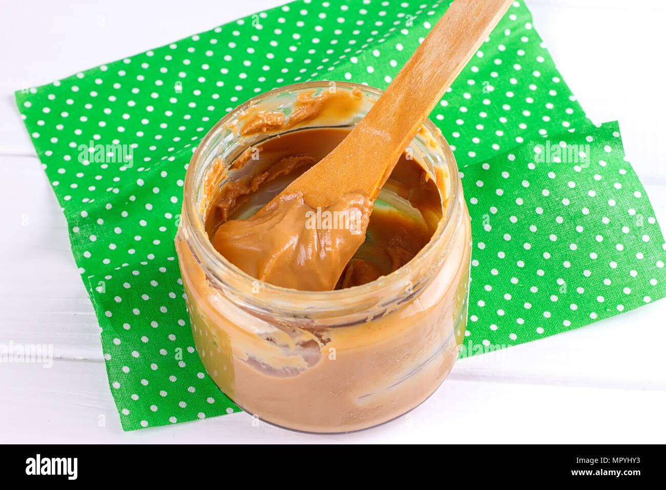 an open jar of peanut butter with spoon Stock Photo Alamy