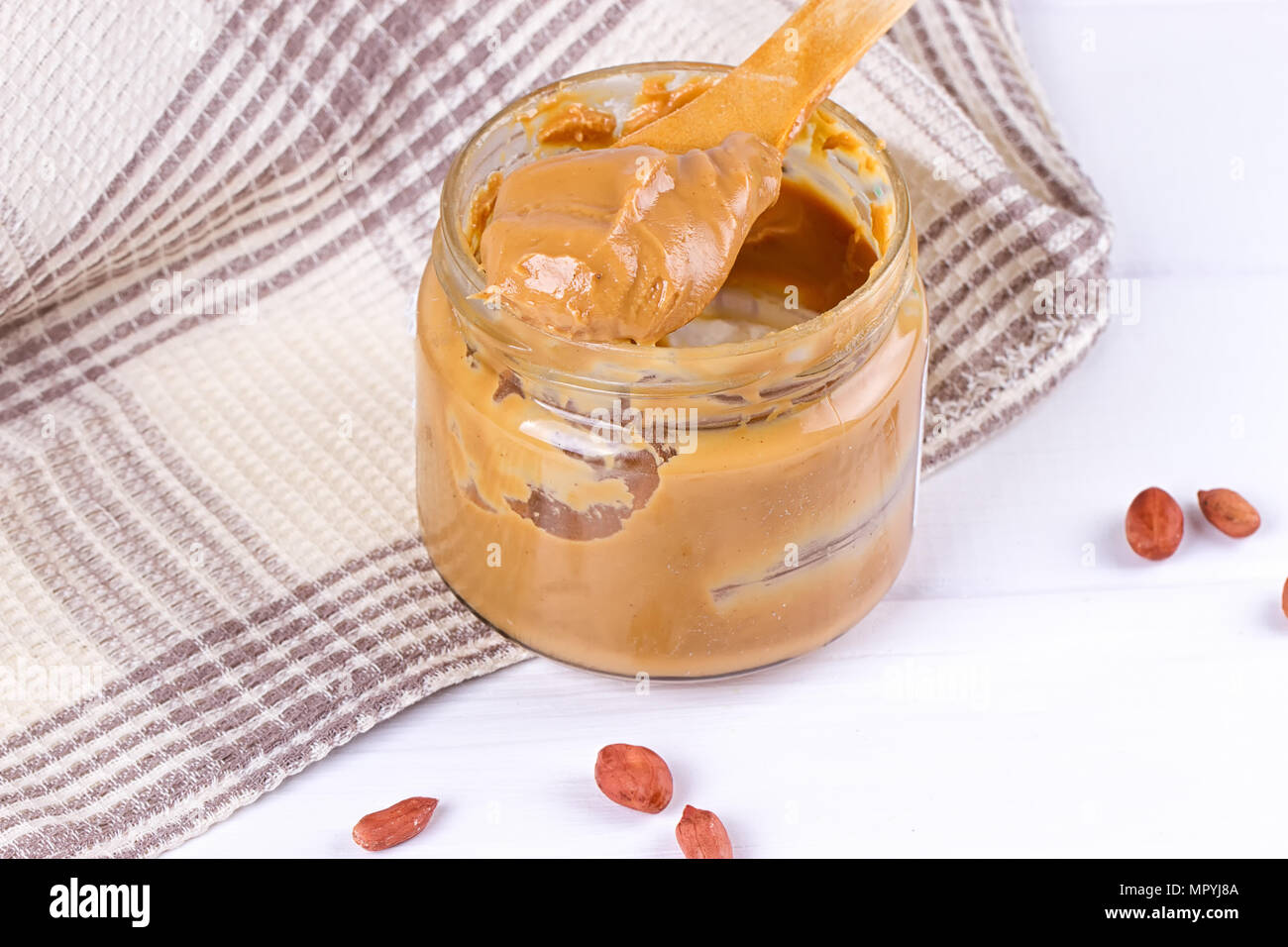 an open jar of peanut butter with spoon Stock Photo Alamy
