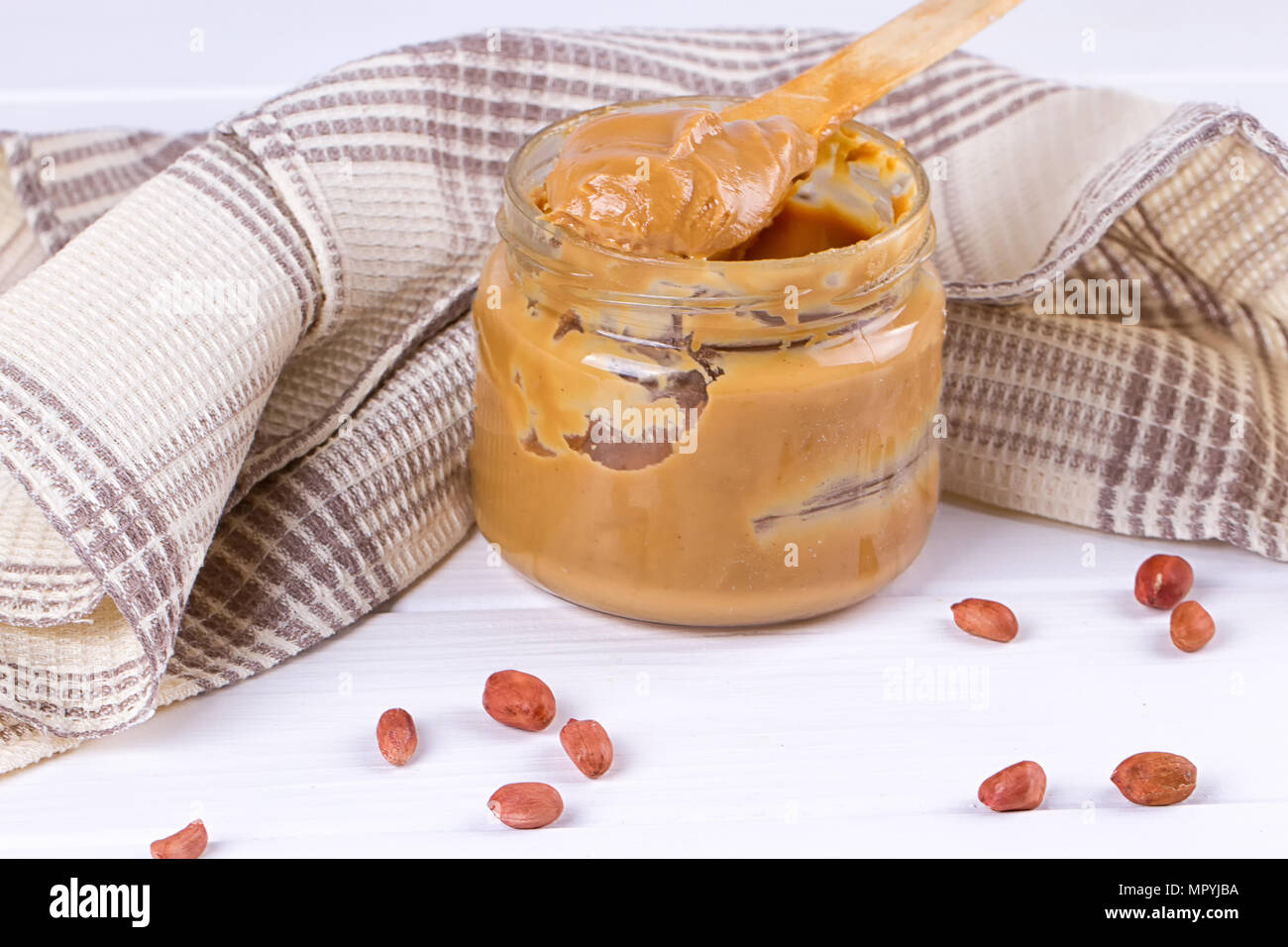 an open jar of peanut butter with spoon Stock Photo Alamy