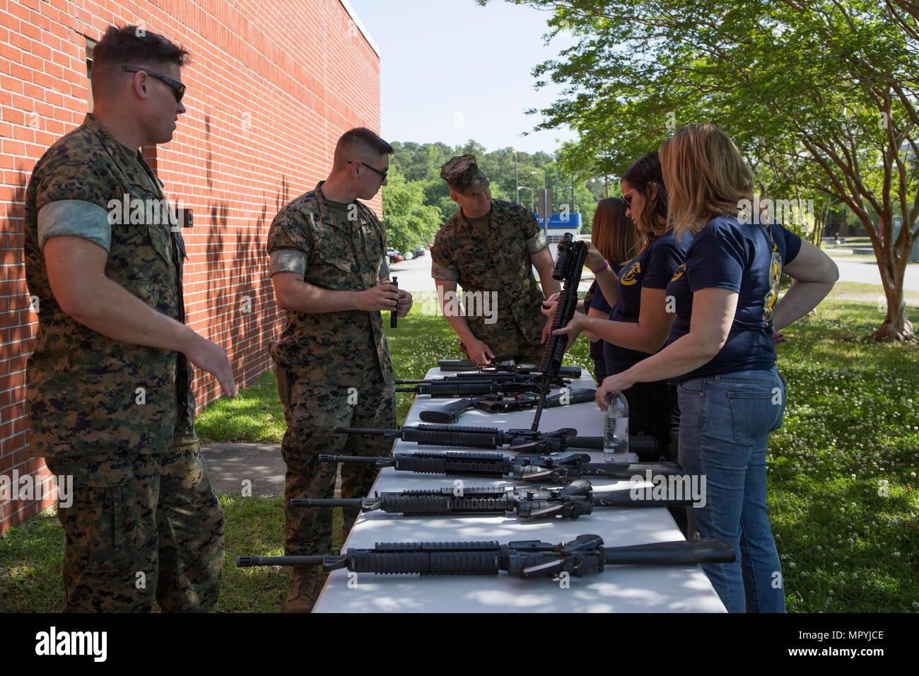 U.S. Marine Corps Corporal Philip J. Breuer, left, and Lance Cpl. Daniel J. Scansen teach the nomenclature of an M16A4 Service Rifle to spouses and family members of Marines and Sailors with II Marine Expeditionary Force (II MEF) during “In Their Boots” day on Camp Lejeune, N.C., April 21, 2017. “In Their Boots” day is an event in which spouses and family members of Marines and Sailors with II MEF are able to participate in various Marine Corps related events and exercises. (U.S. Marine Corps photo by Lance Cpl. Taylor N. Cooper) Stock Photo